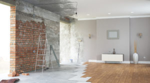 a luxurious looking room that is halfway through renovation, with exposed brick wall, ceiling, and floor.